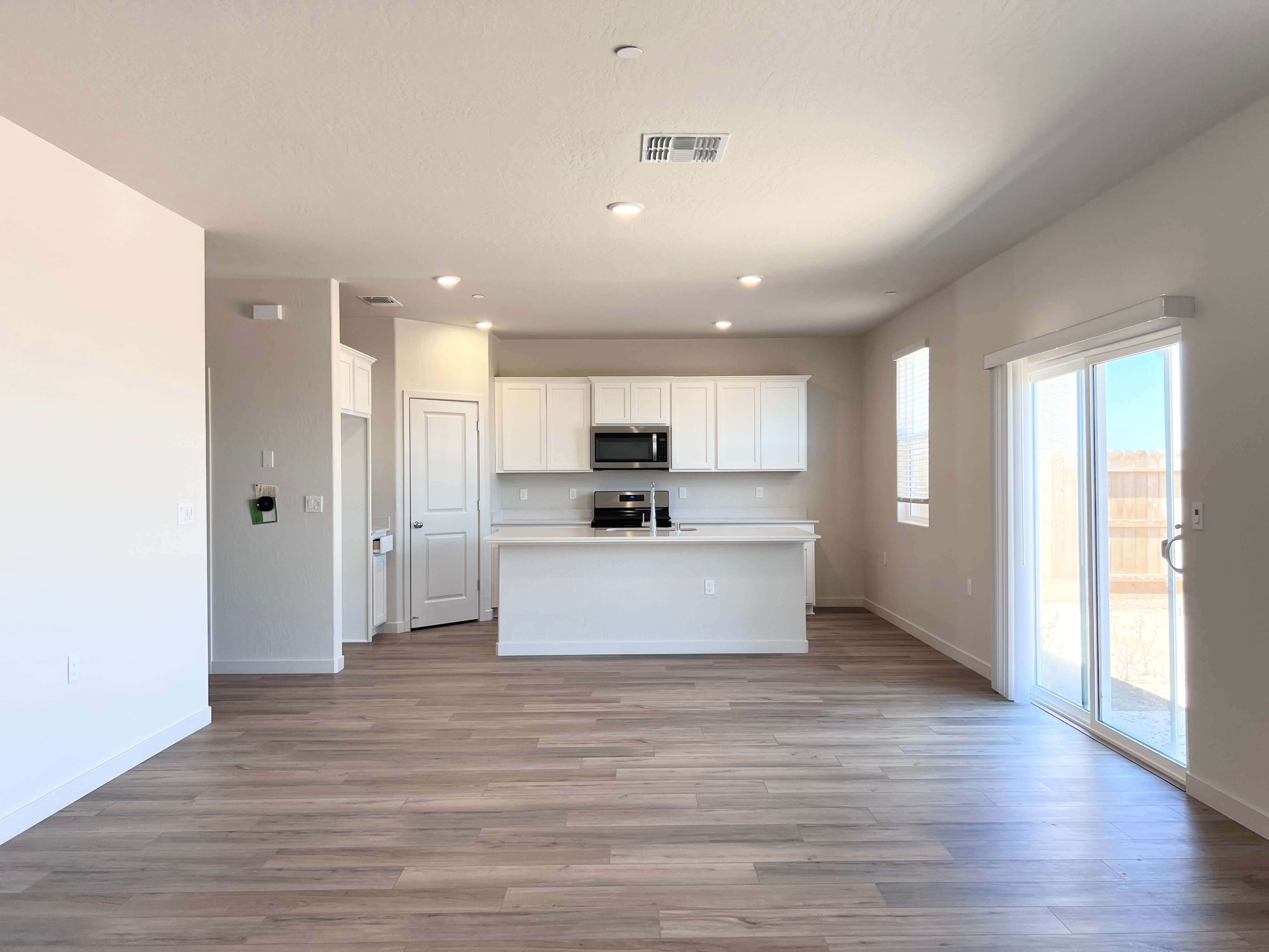 A large empty room with white cabinets.