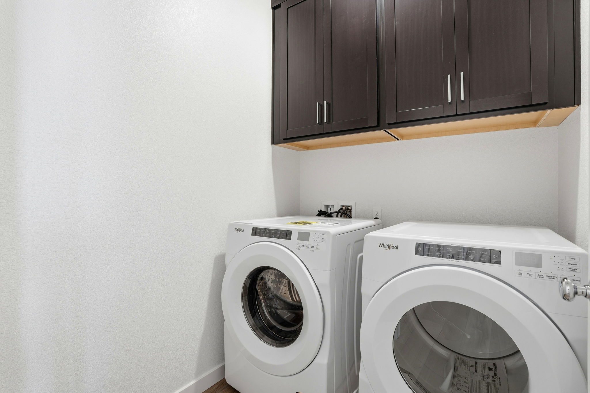 A washing machine and dryer in a room.
