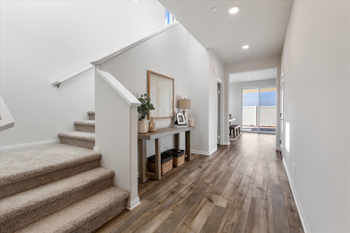 A room with a wood floor and a wood floor with a table and a chair and a rug.