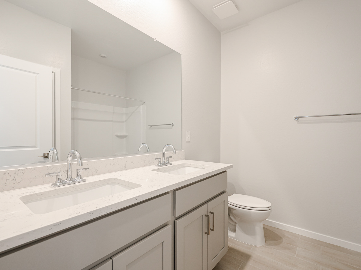 A bathroom with a toilet sink and mirror.