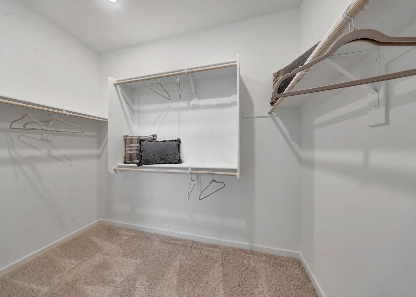 A white room with a shelf and a mirror.