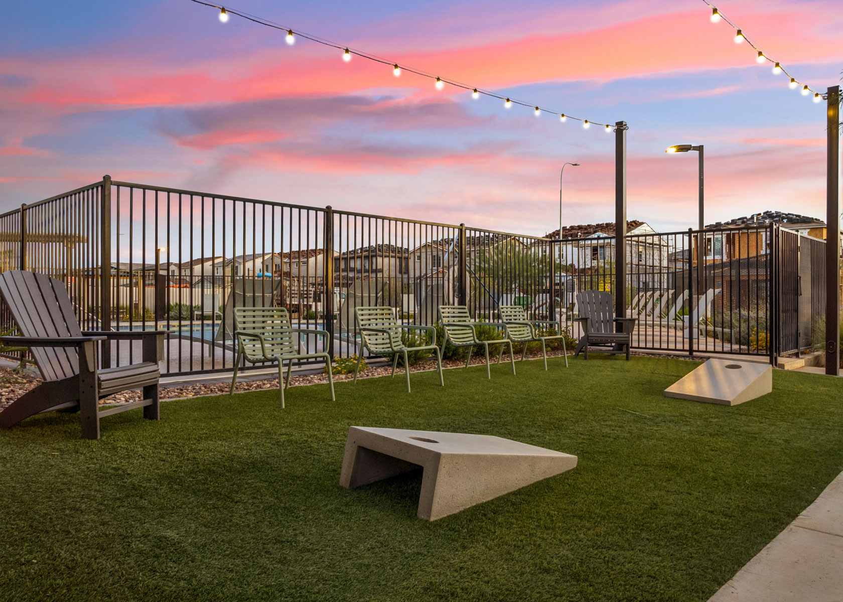 A park with benches and a fence.