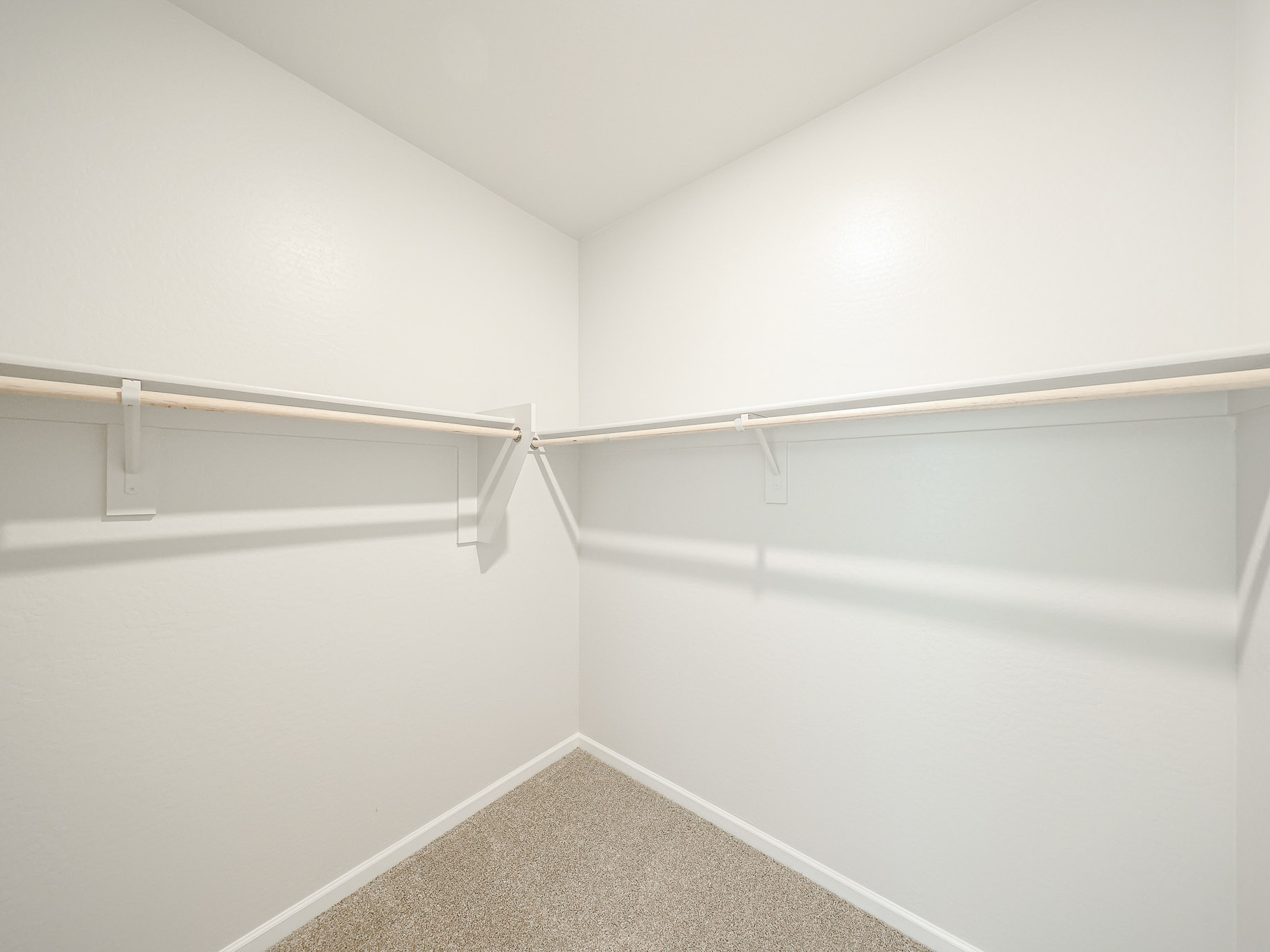 A white wall with a metal bar.