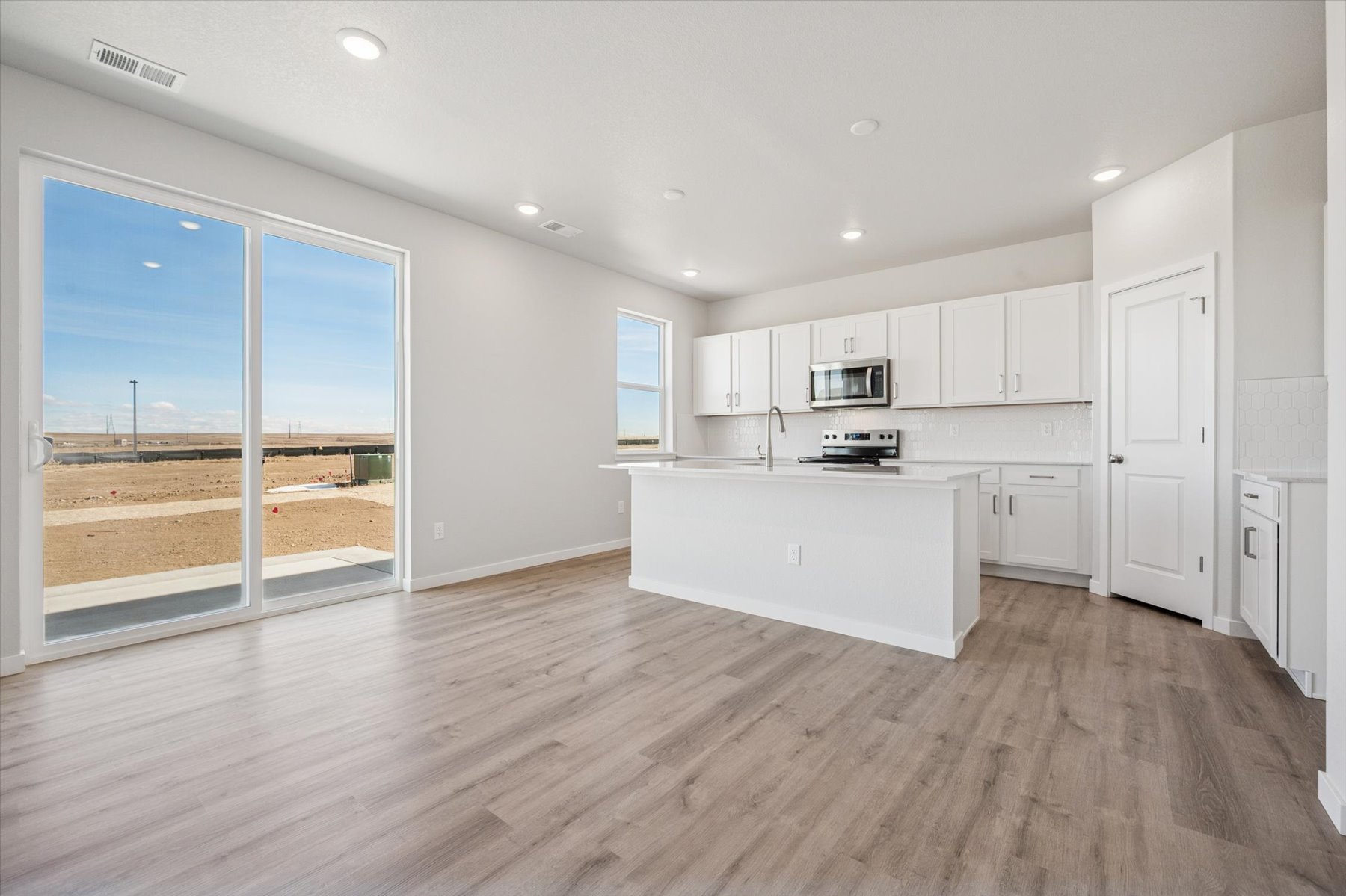 A kitchen with white cabinets.