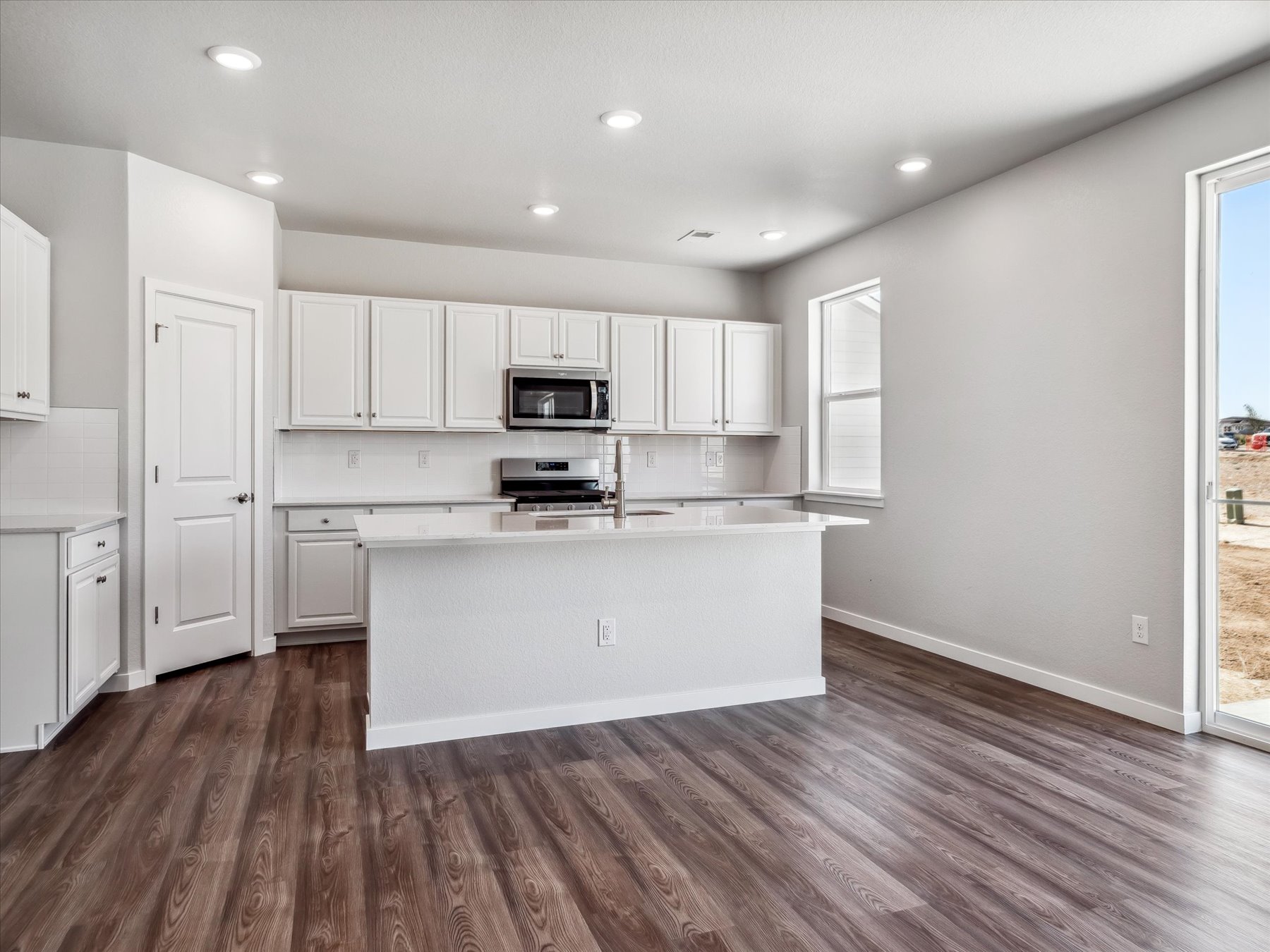 A kitchen with white cabinets.