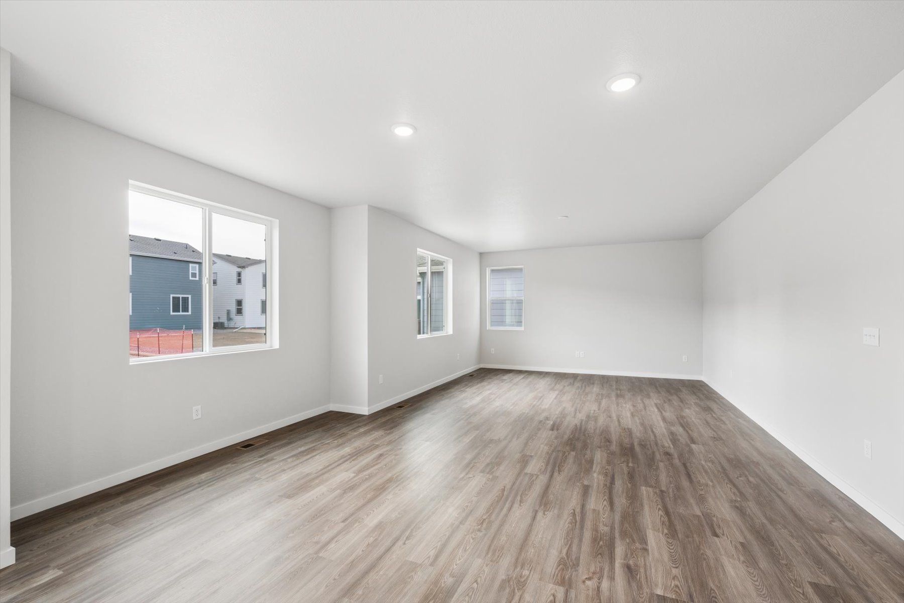 A room with a wood floor and windows.