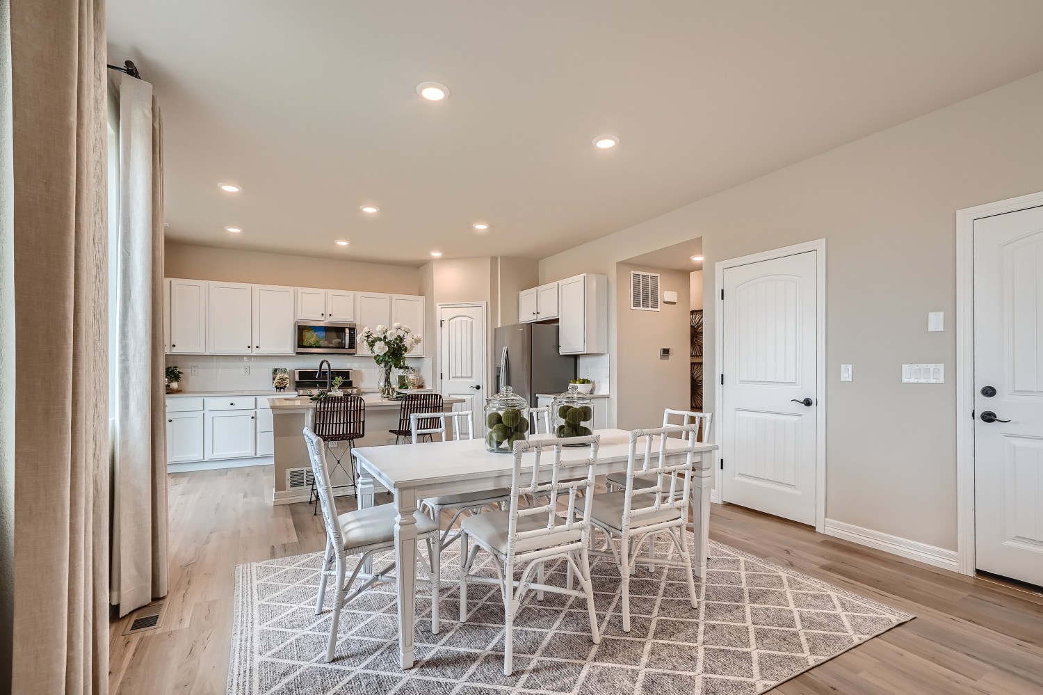 A kitchen with a dining table and chairs.