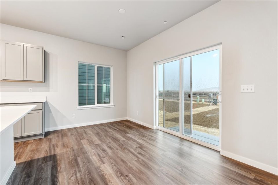 A room with a wood floor and a large window.