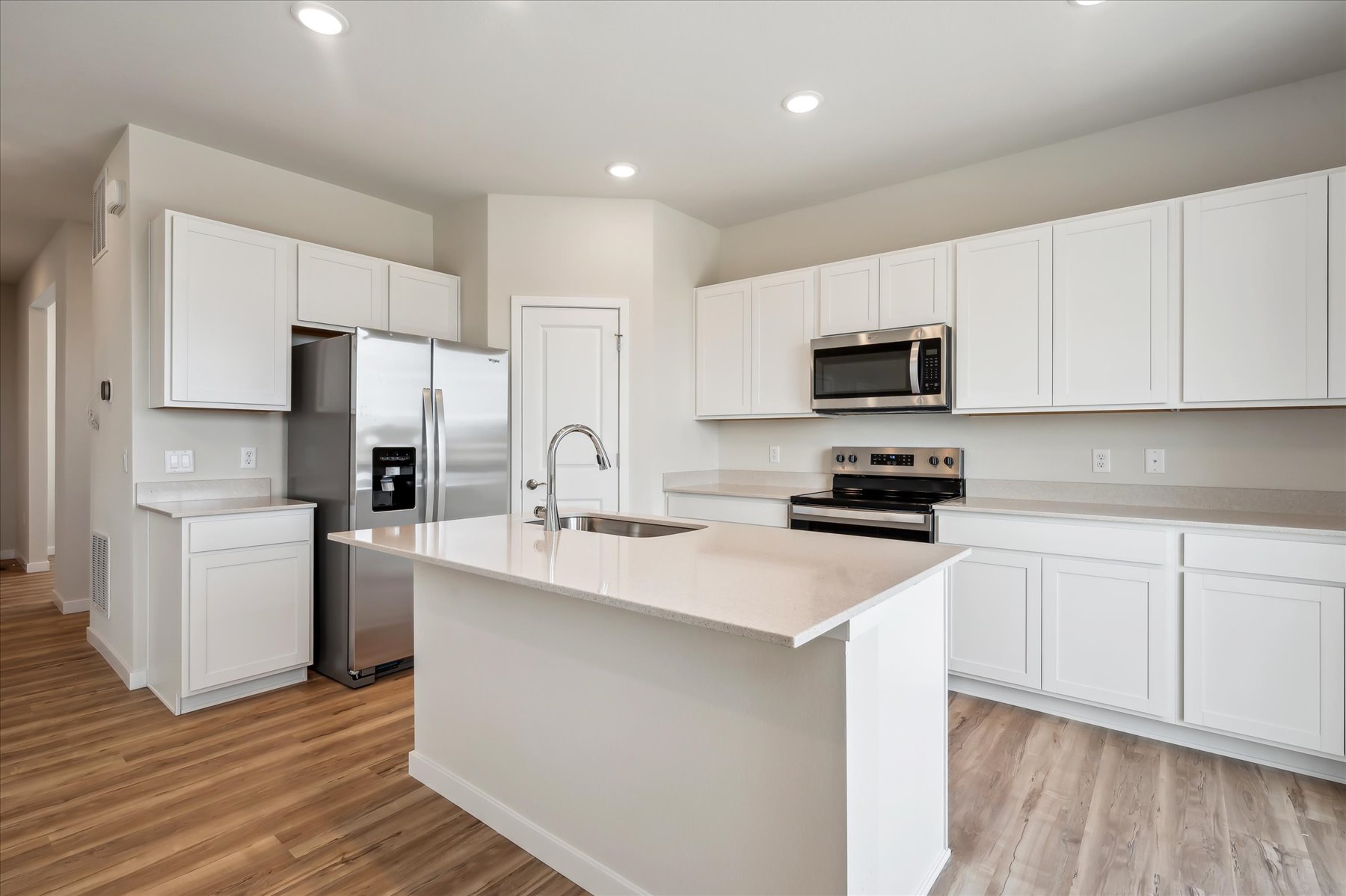 A kitchen with white cabinets.
