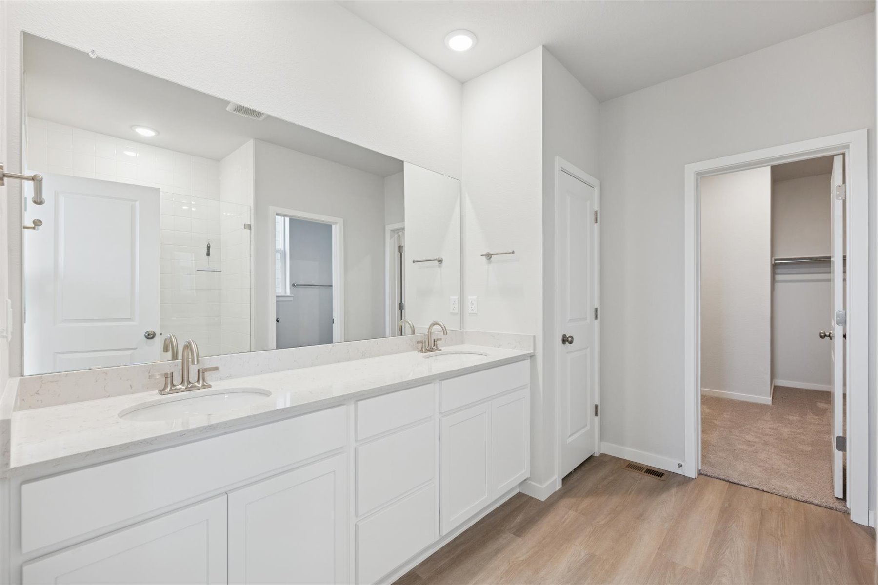 A bathroom with white cabinets.