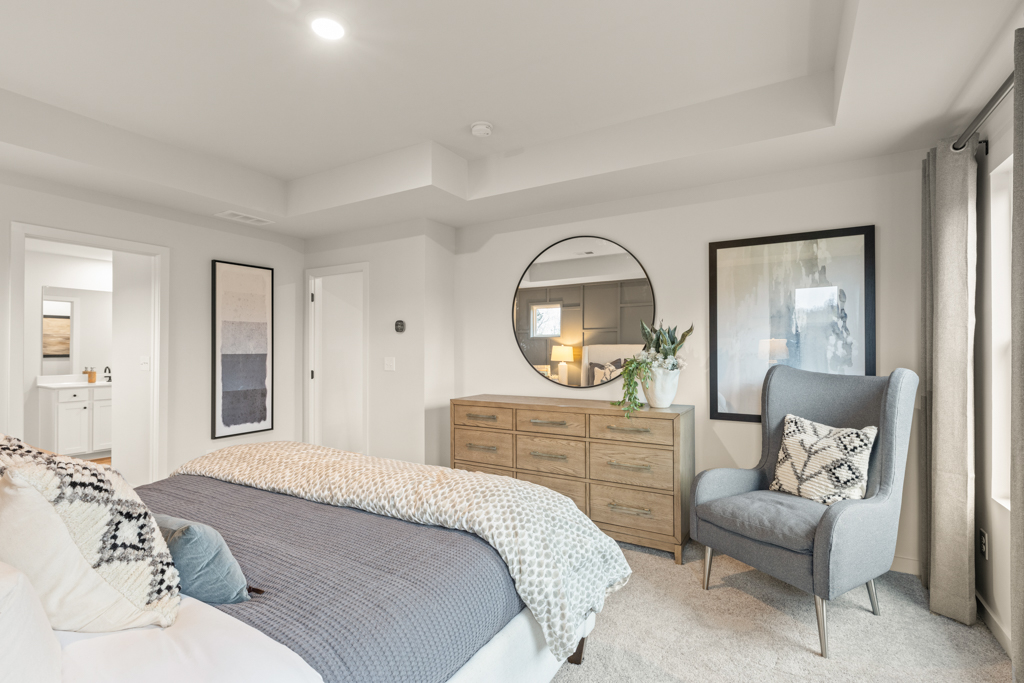 A bedroom with a bed and a chair.