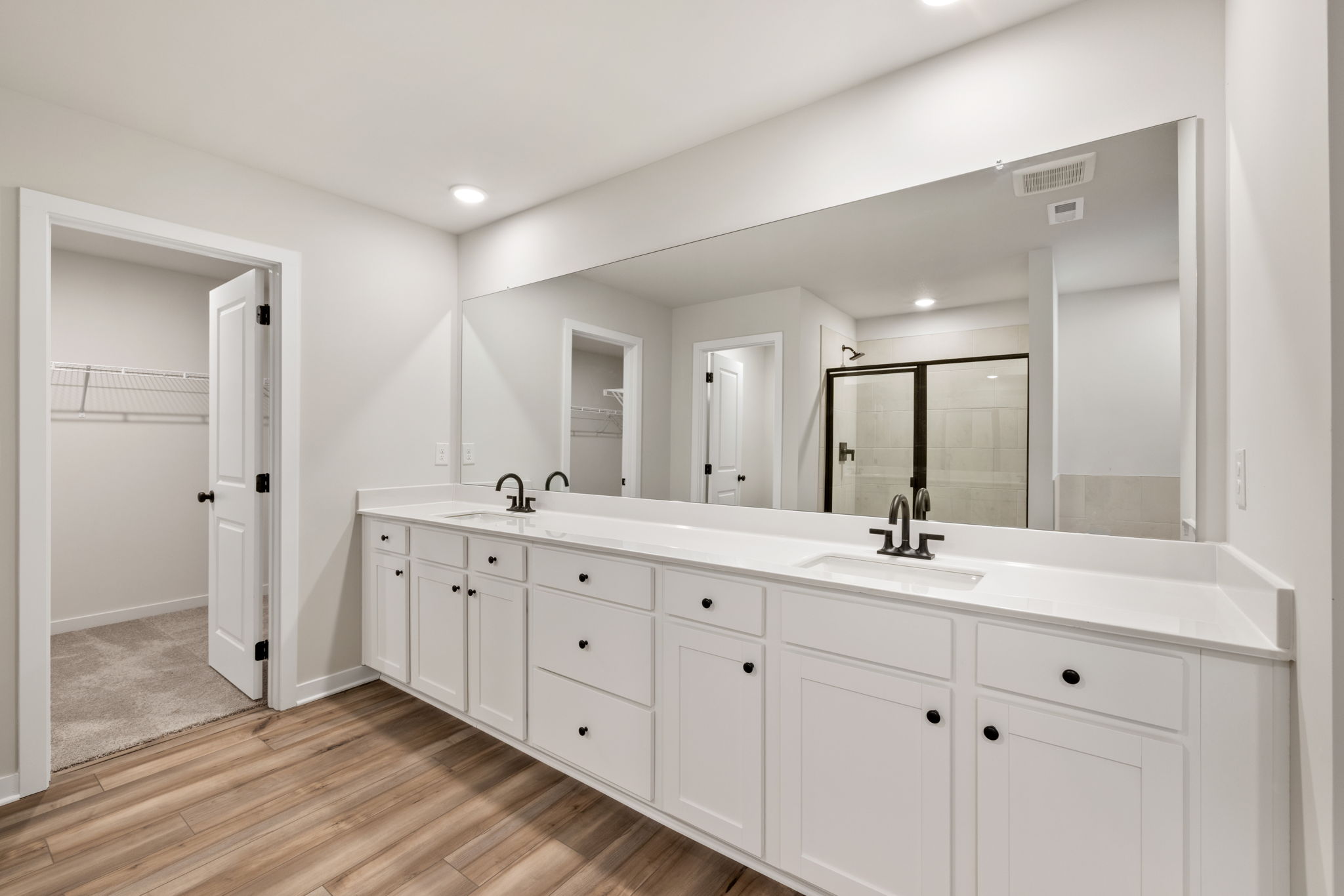 A bathroom with white cabinets.