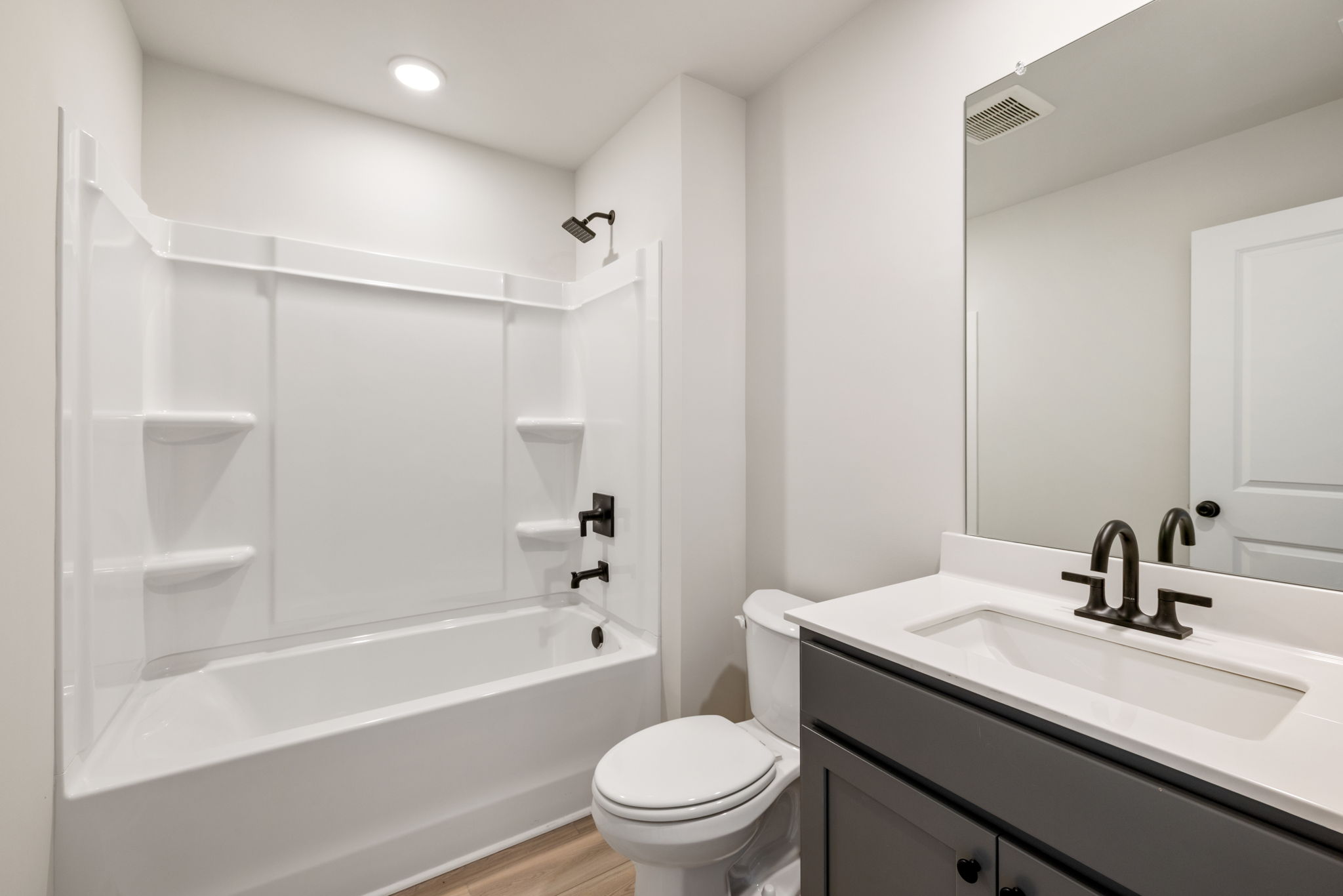 A bathroom with a tub sink and toilet.