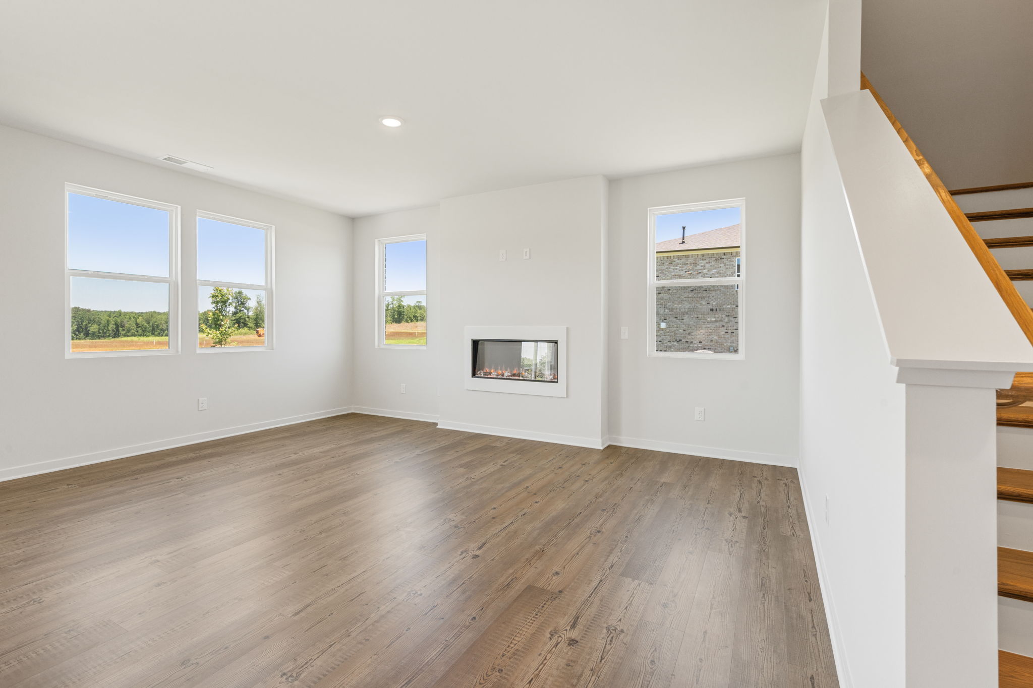 A room with a wood floor and windows.