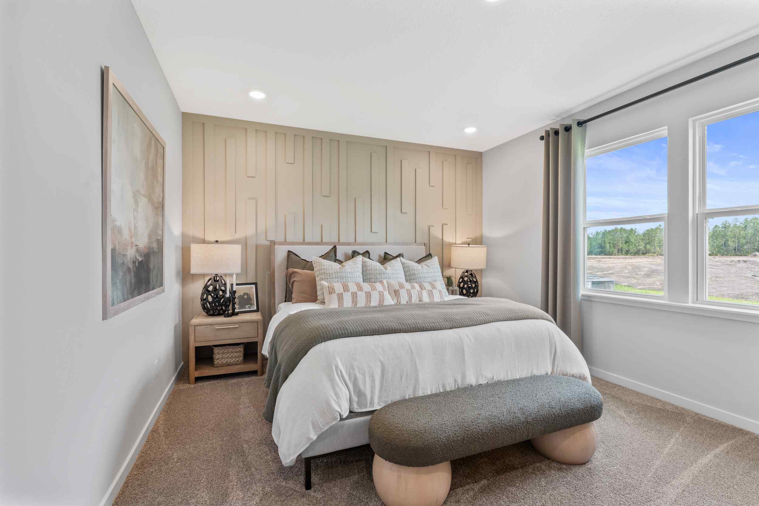 Silverbell II Model Home Primary Room with King Bed and End Couch at Camden Woods in Kingsland, GA.