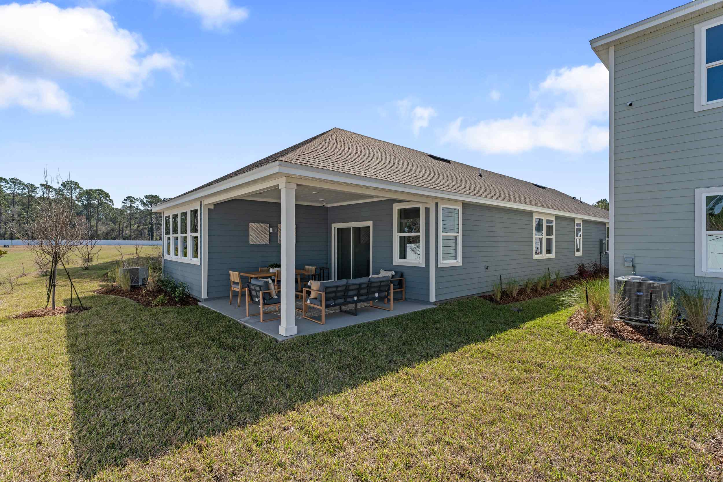 A house with a lawn and chairs.
