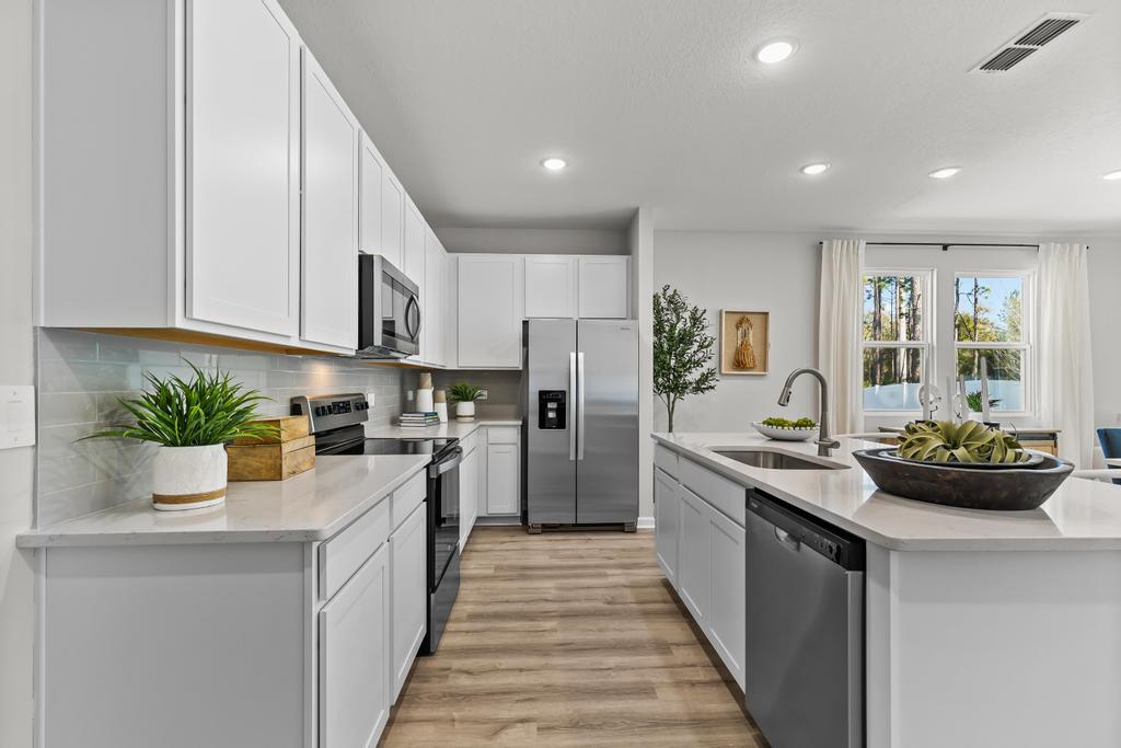 A kitchen with white cabinets.