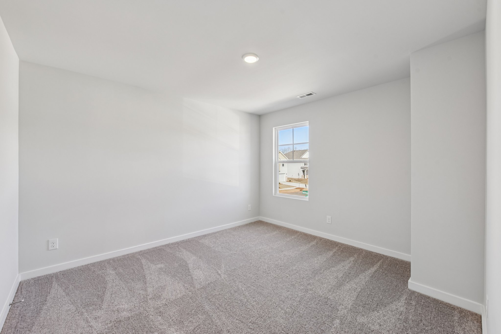 A room with a window and a carpet.