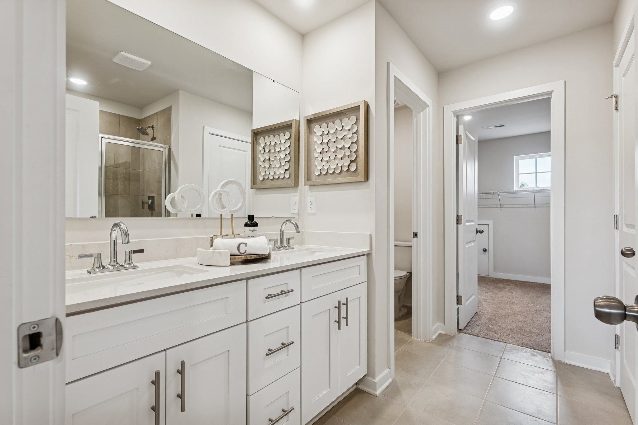 A bathroom with white cabinets.