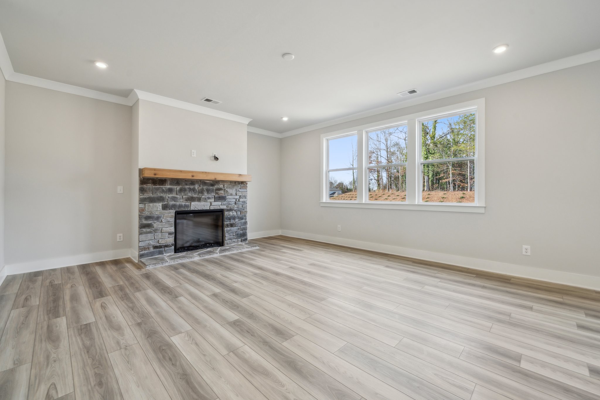 A room with a fireplace and a wood floor.
