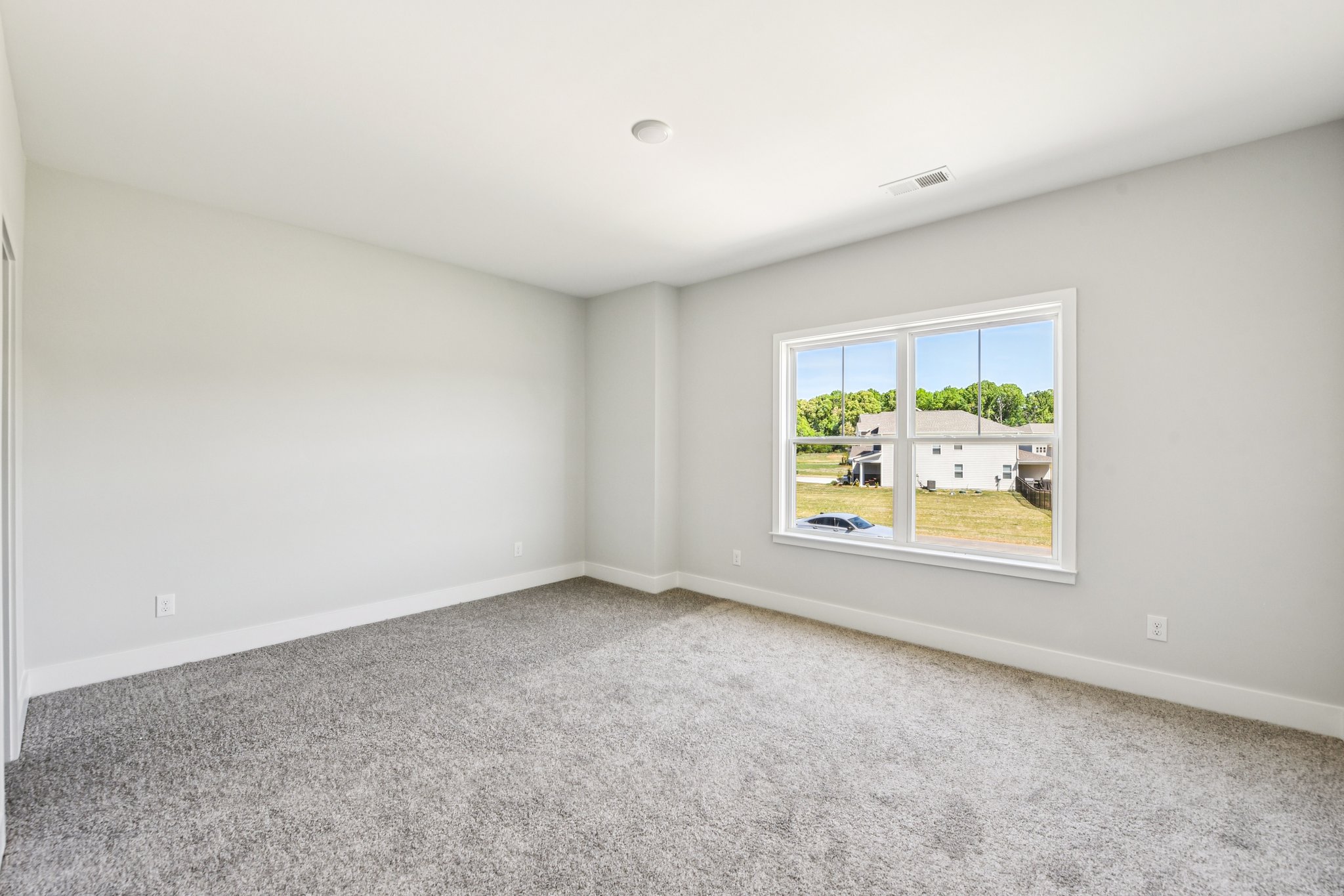 A room with a window and a carpet.