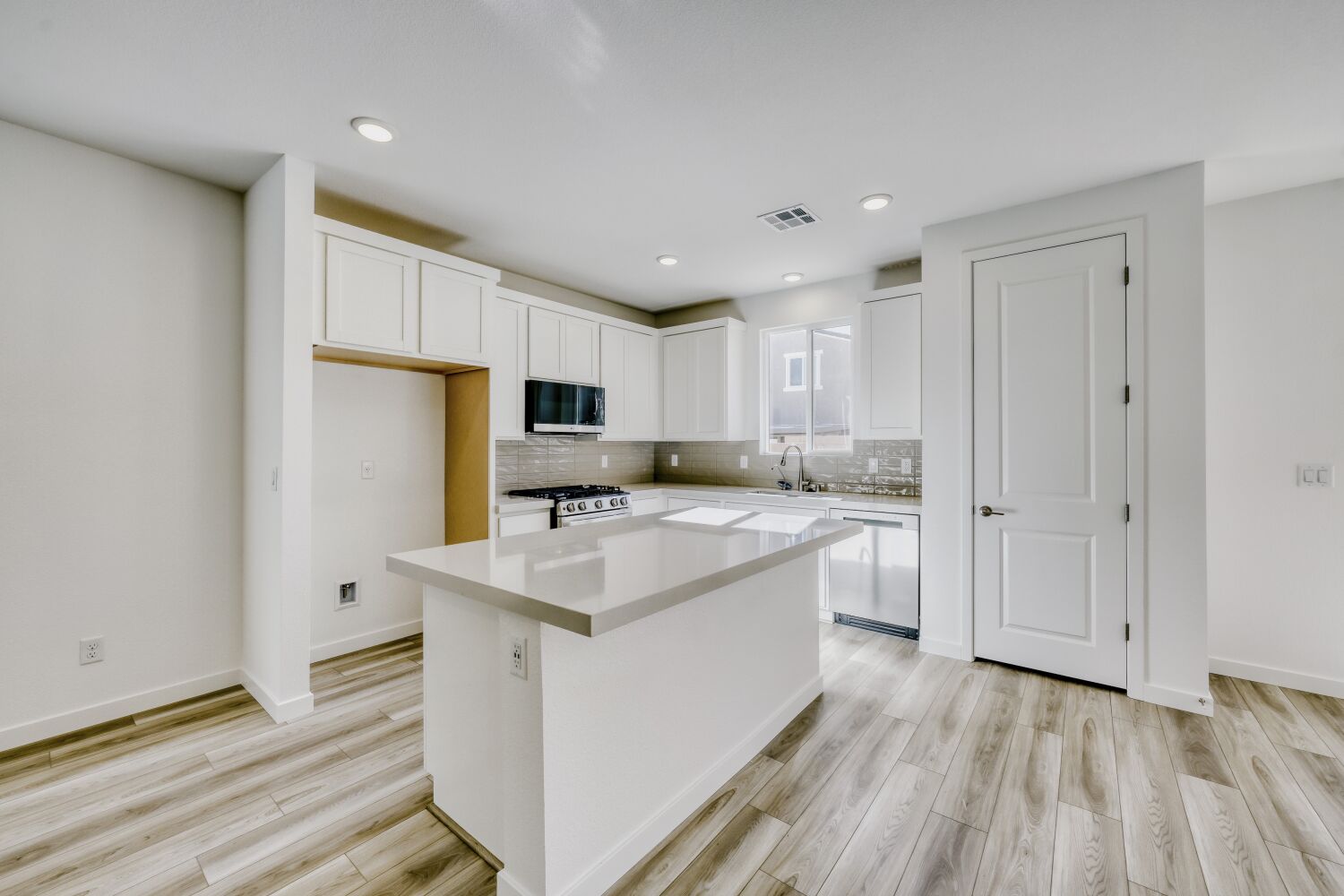 A kitchen with white cabinets.