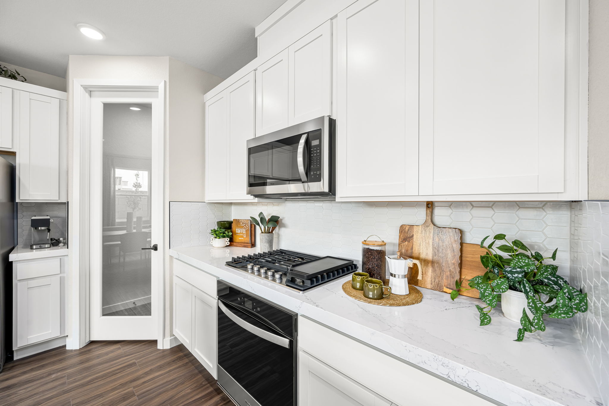 A kitchen with white cabinets.