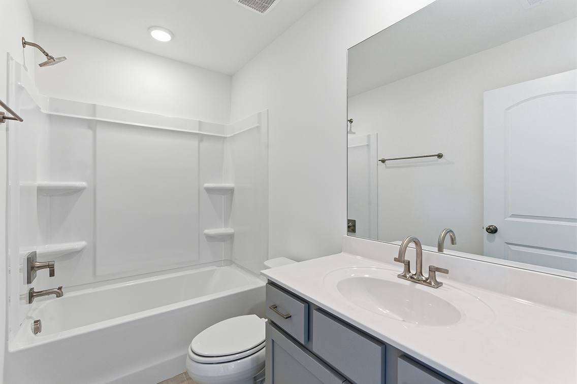 A bathroom with a tub sink and toilet.