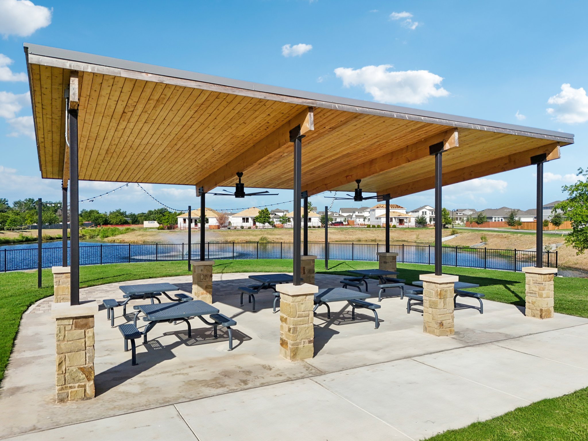 A covered area with benches and a body of water in the background.