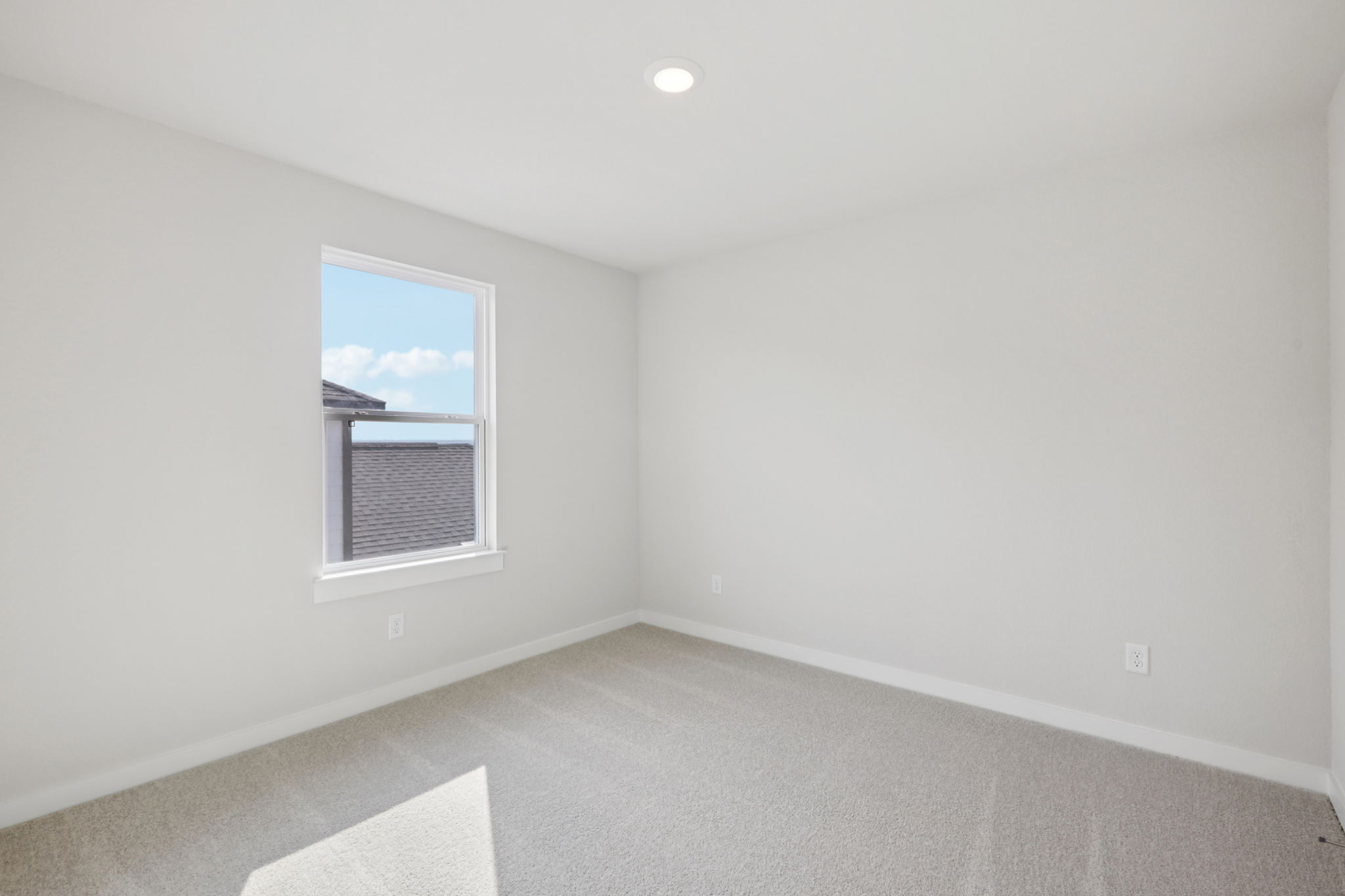 A room with a window and a rug.