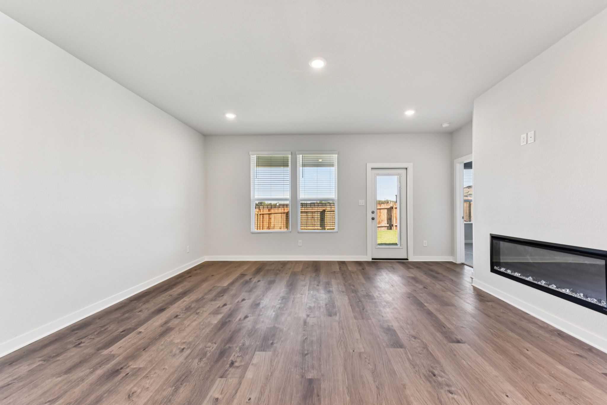 A room with a wood floor and a wood floor with a window.