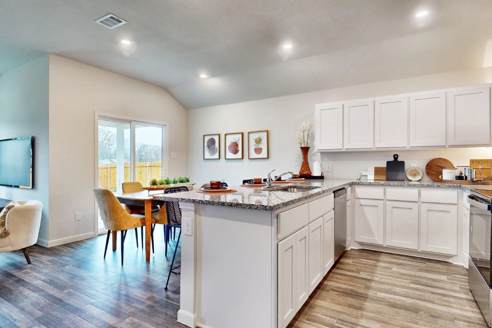 A kitchen with white cabinets.