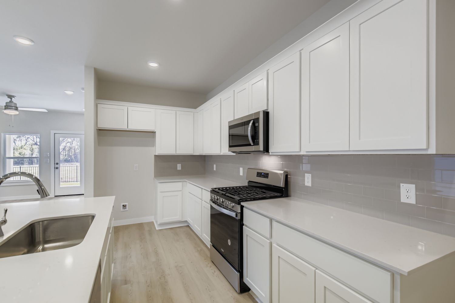 A kitchen with white cabinets.