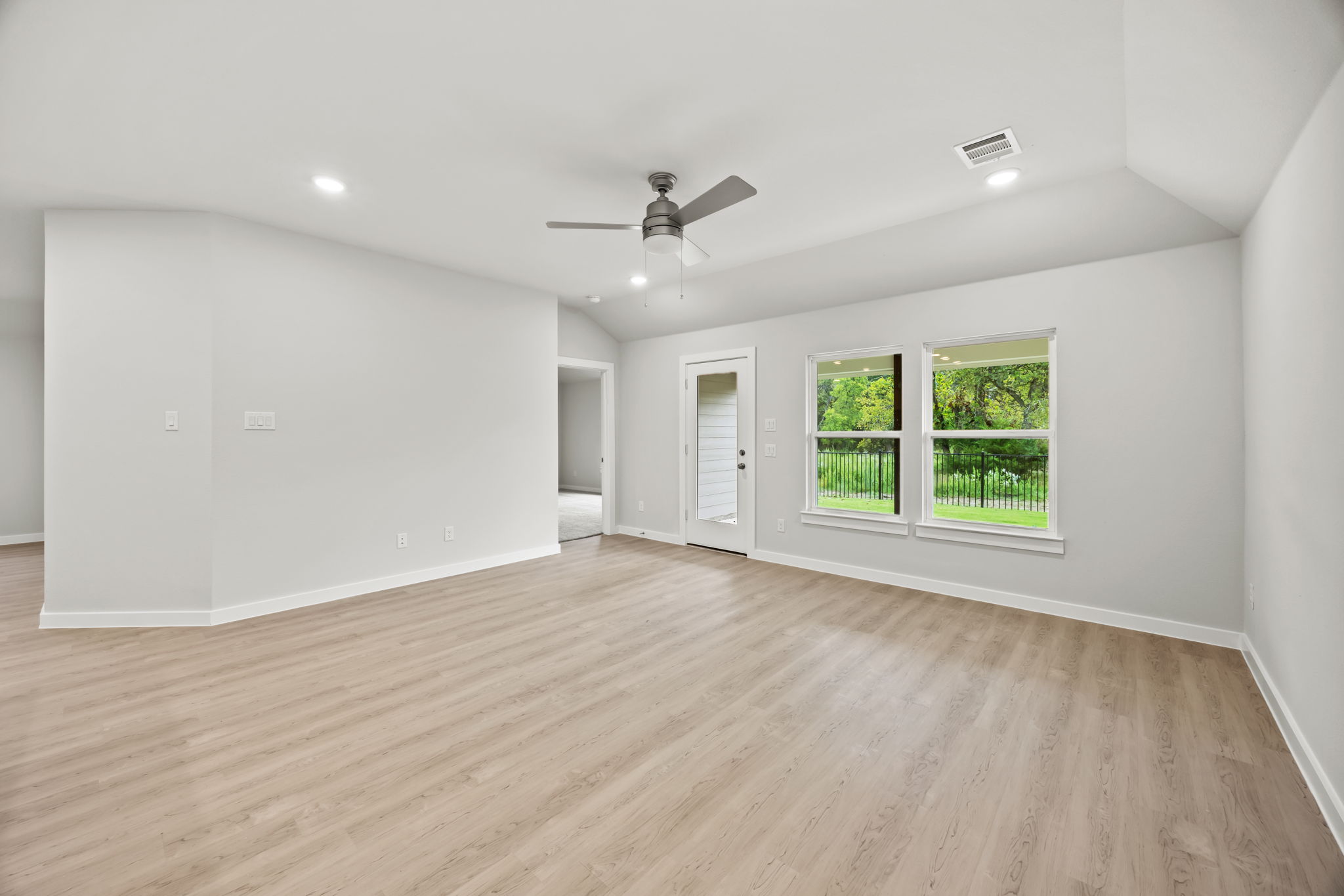 A room with a wood floor and a ceiling fan.