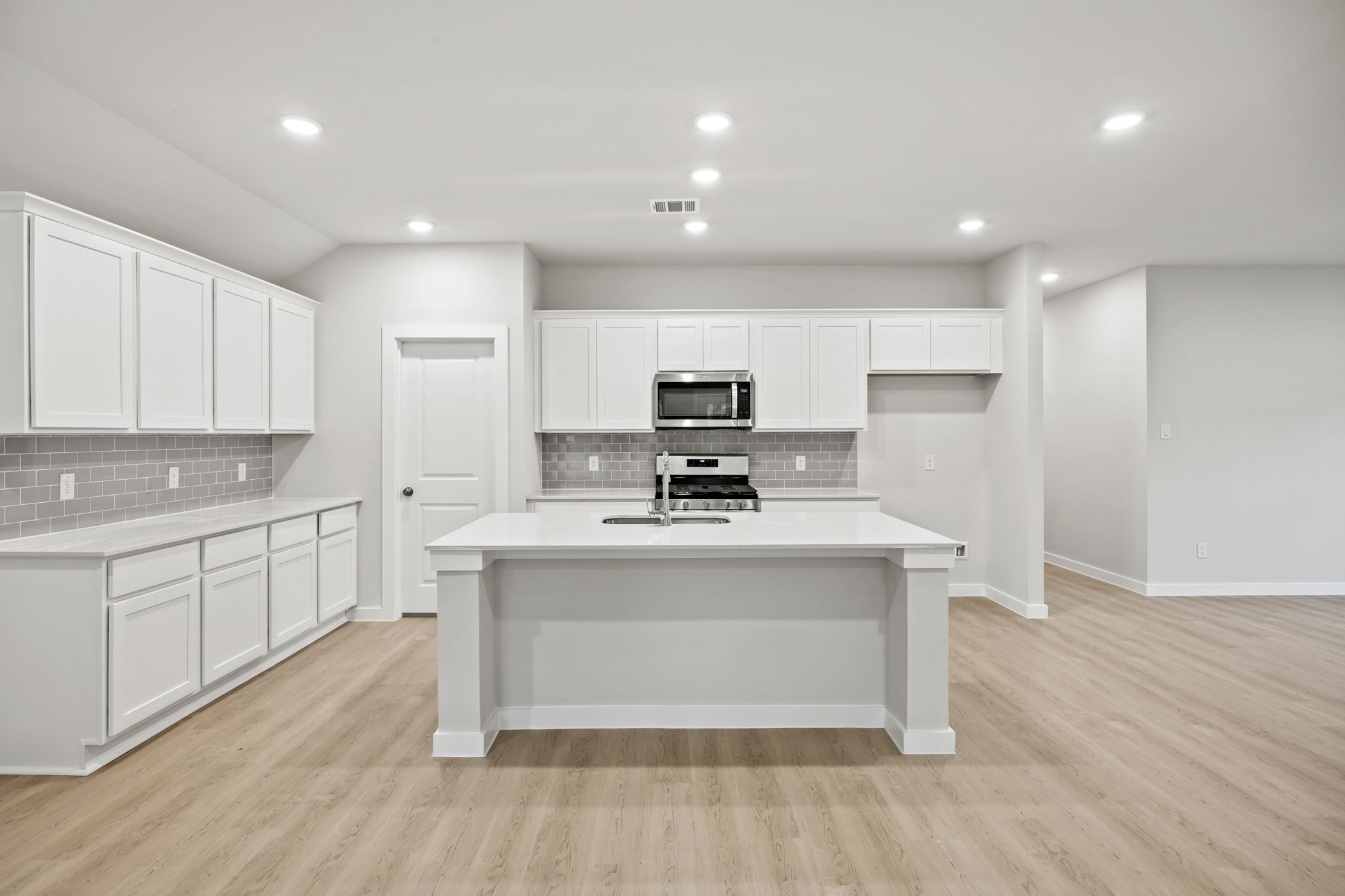 A kitchen with white cabinets.