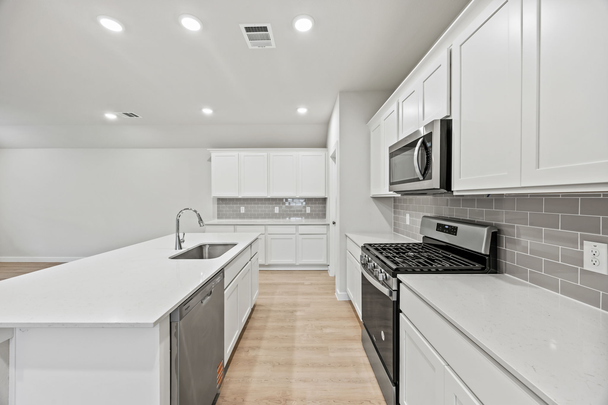 A kitchen with white cabinets.