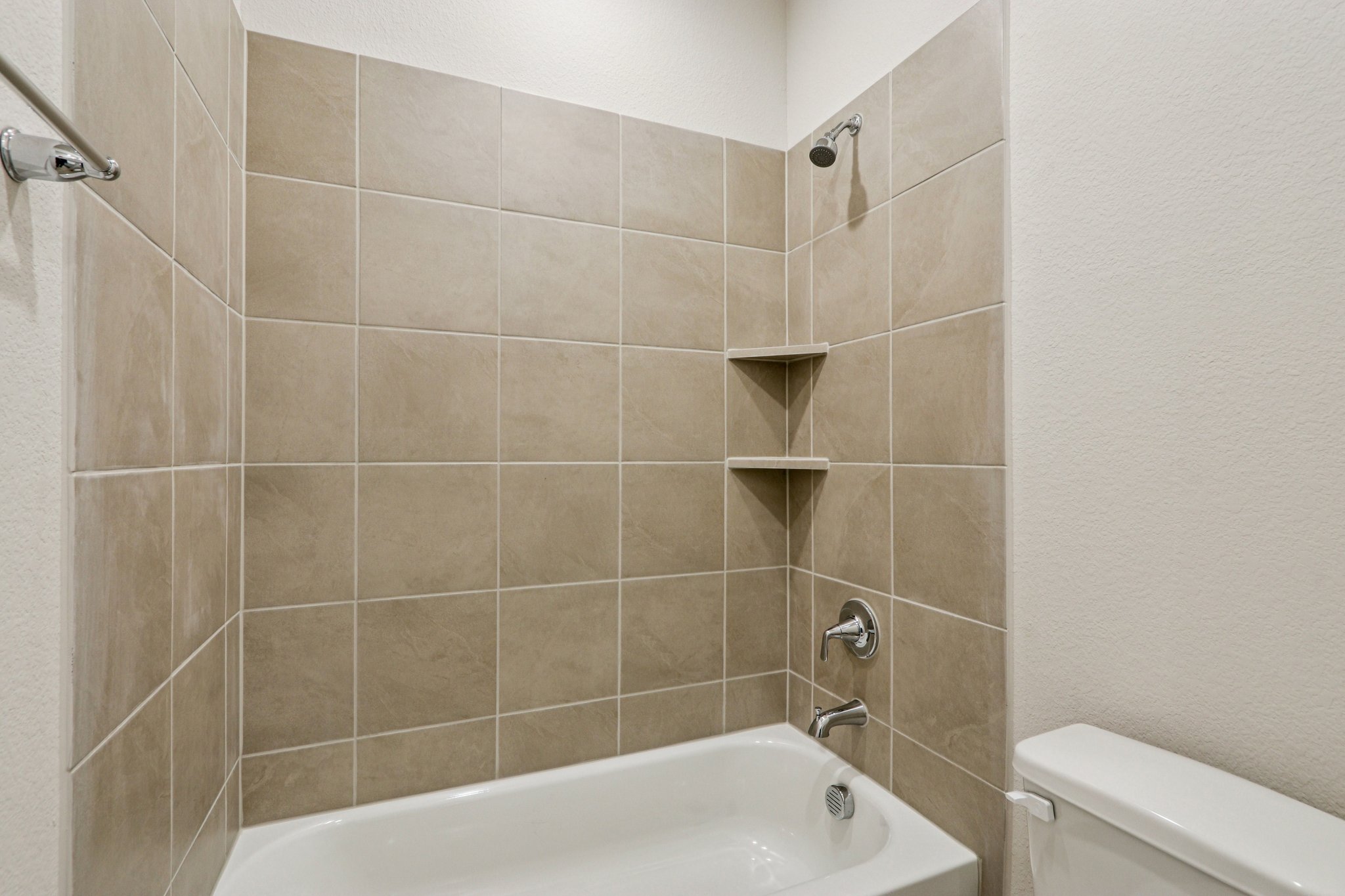 A bathroom with a bathtub and shelves.
