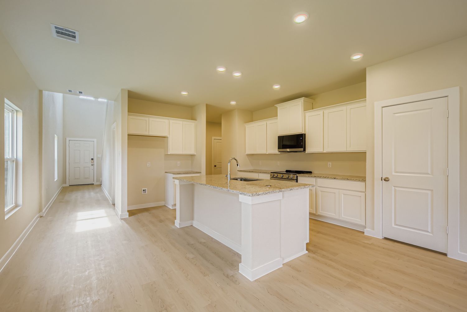 A kitchen with white cabinets.