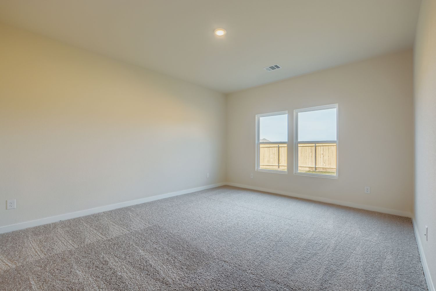 A room with a carpet and windows.
