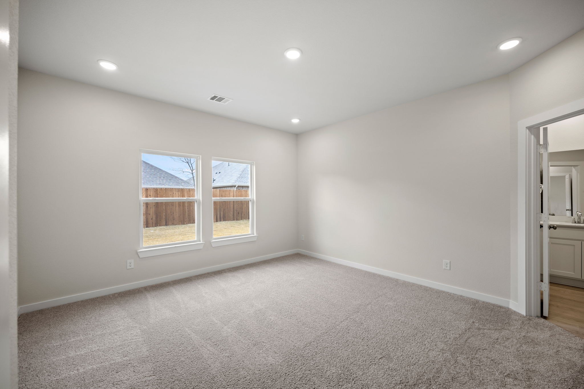 A room with a white wall and windows.
