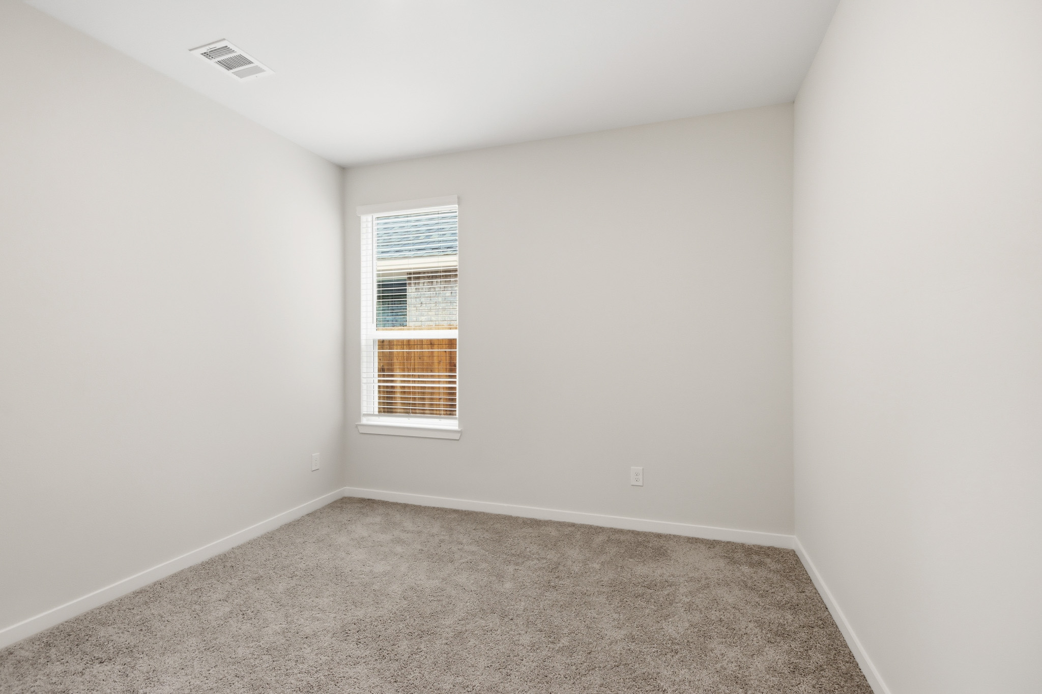 A room with a carpet and a window.