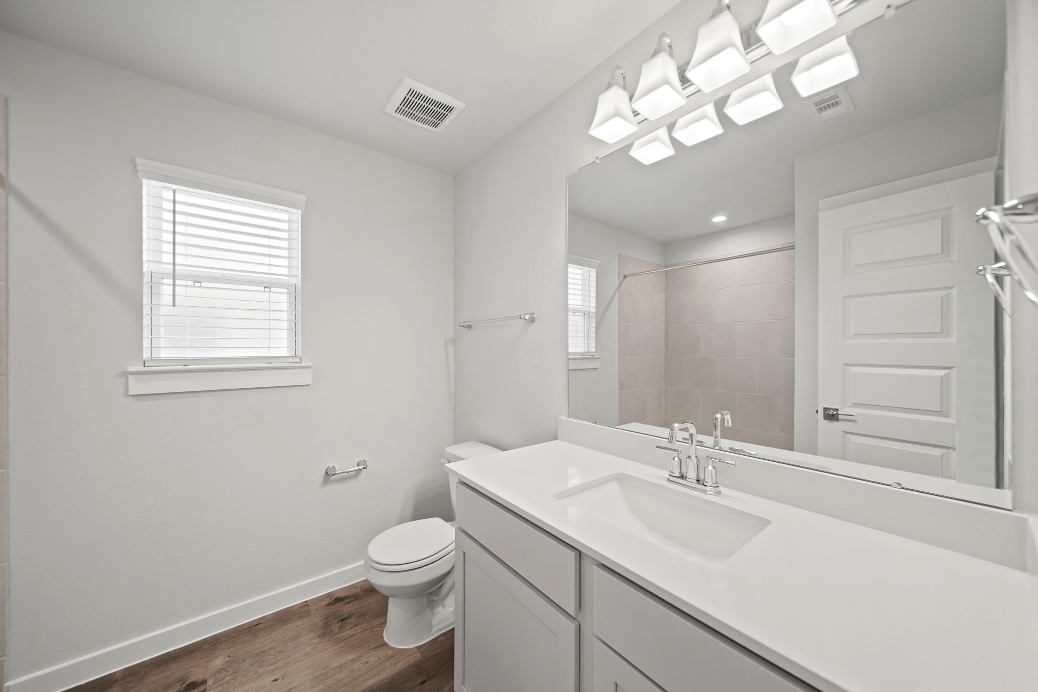 A bathroom with a large mirror.