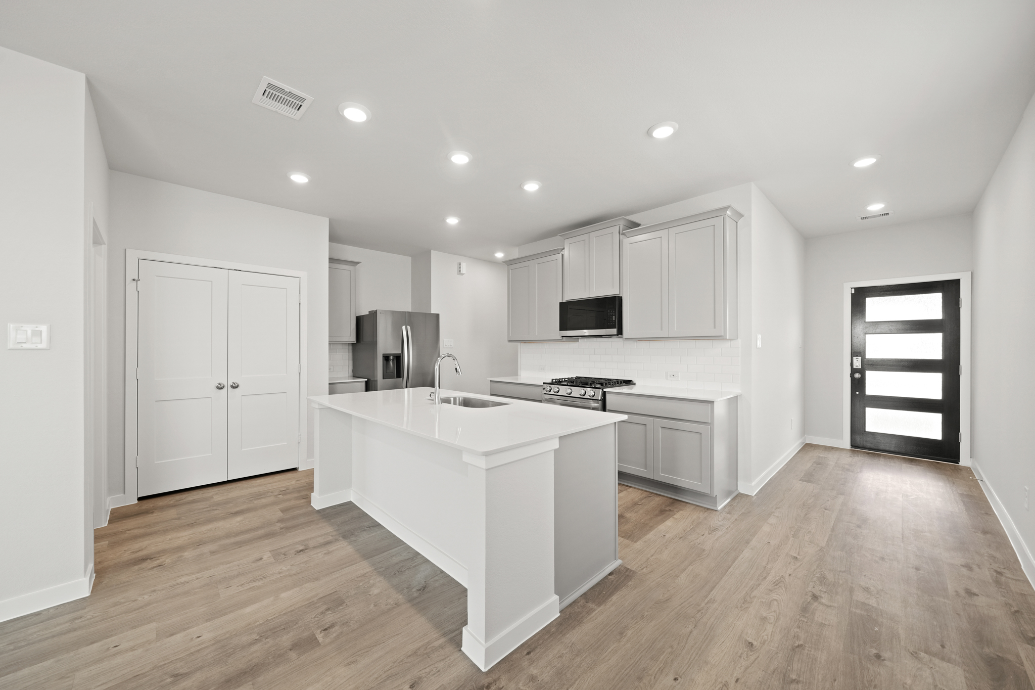 A kitchen with white cabinets.