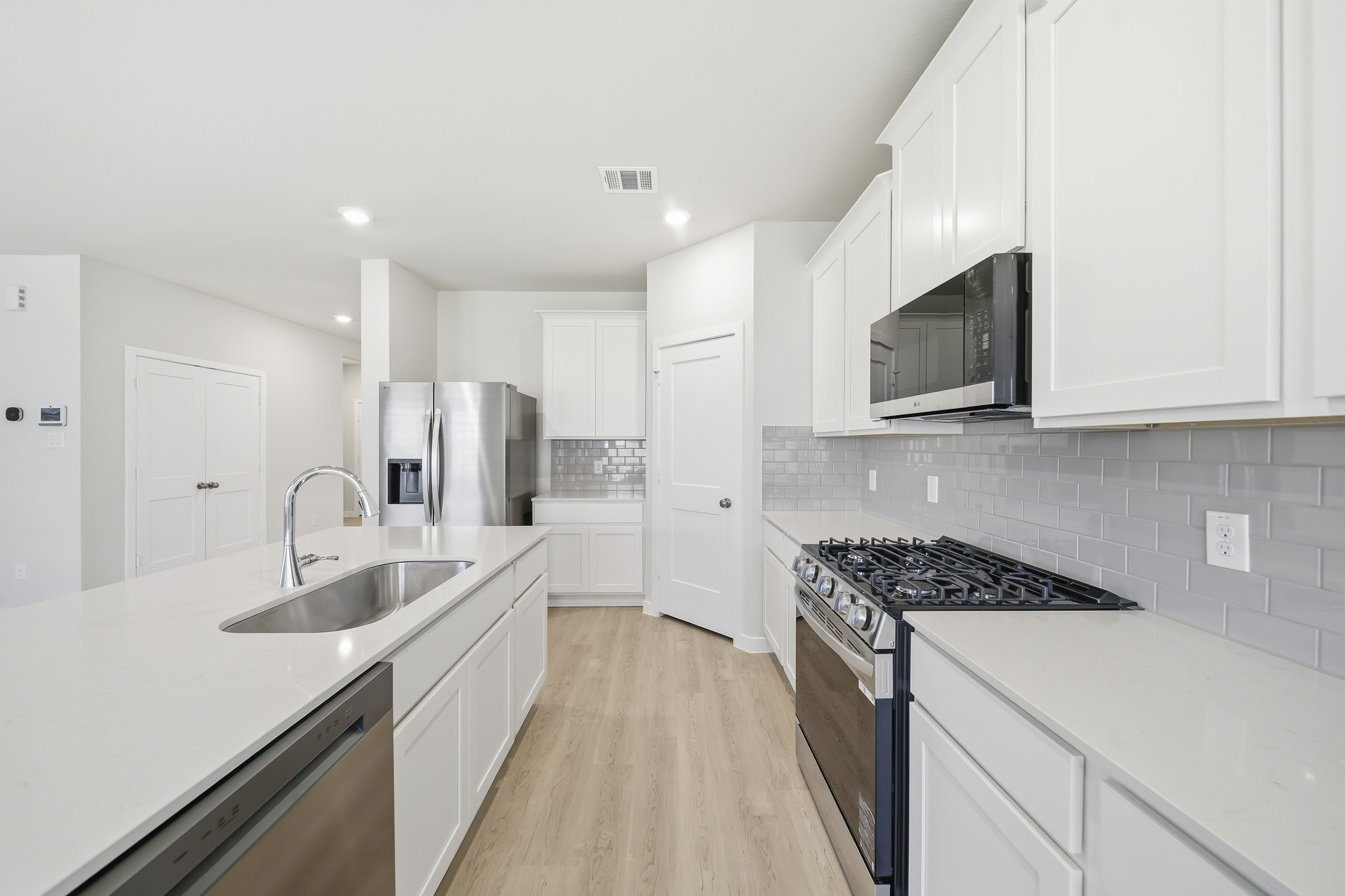 A kitchen with white cabinets.