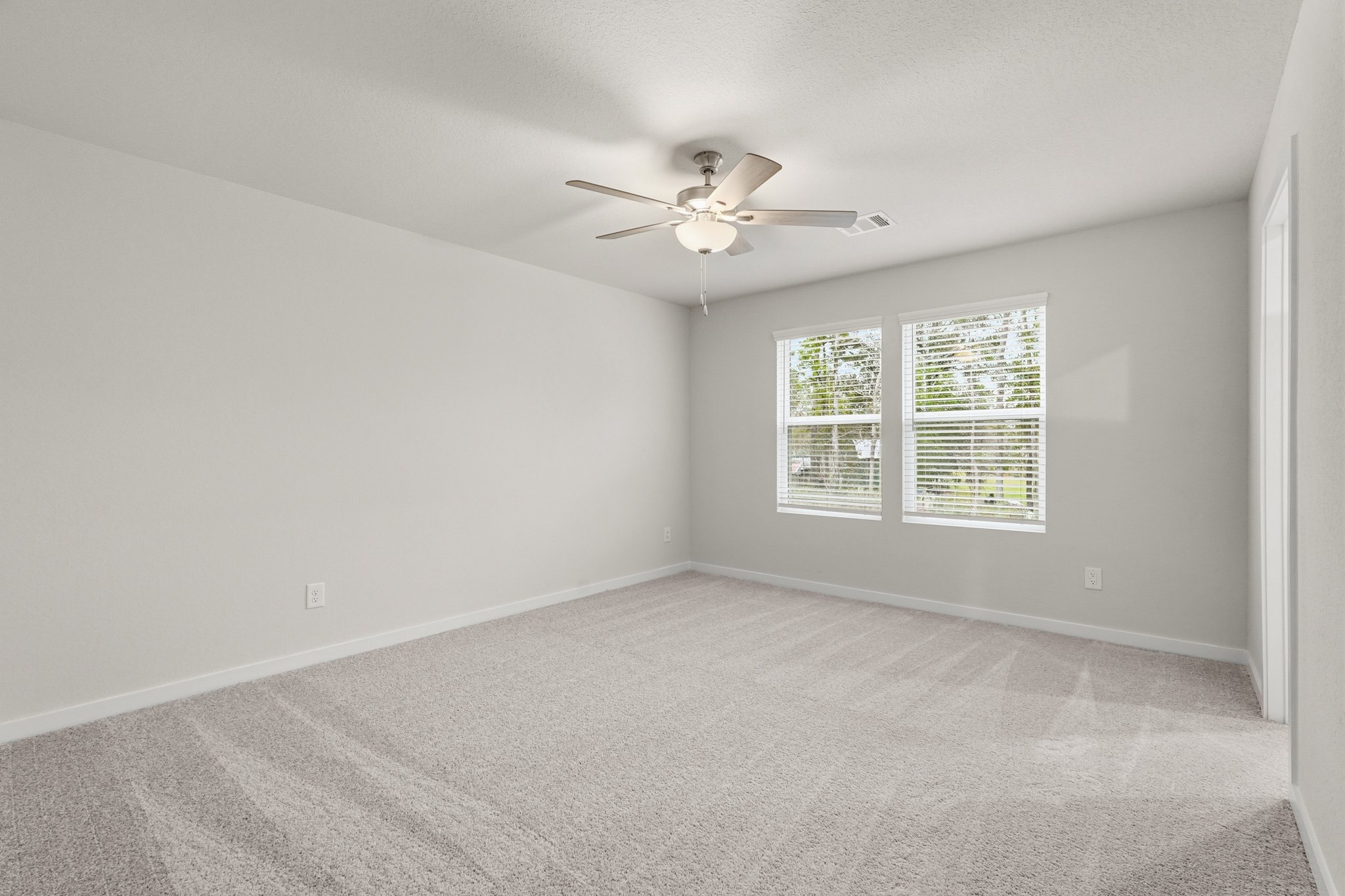 A room with a ceiling fan and a window.