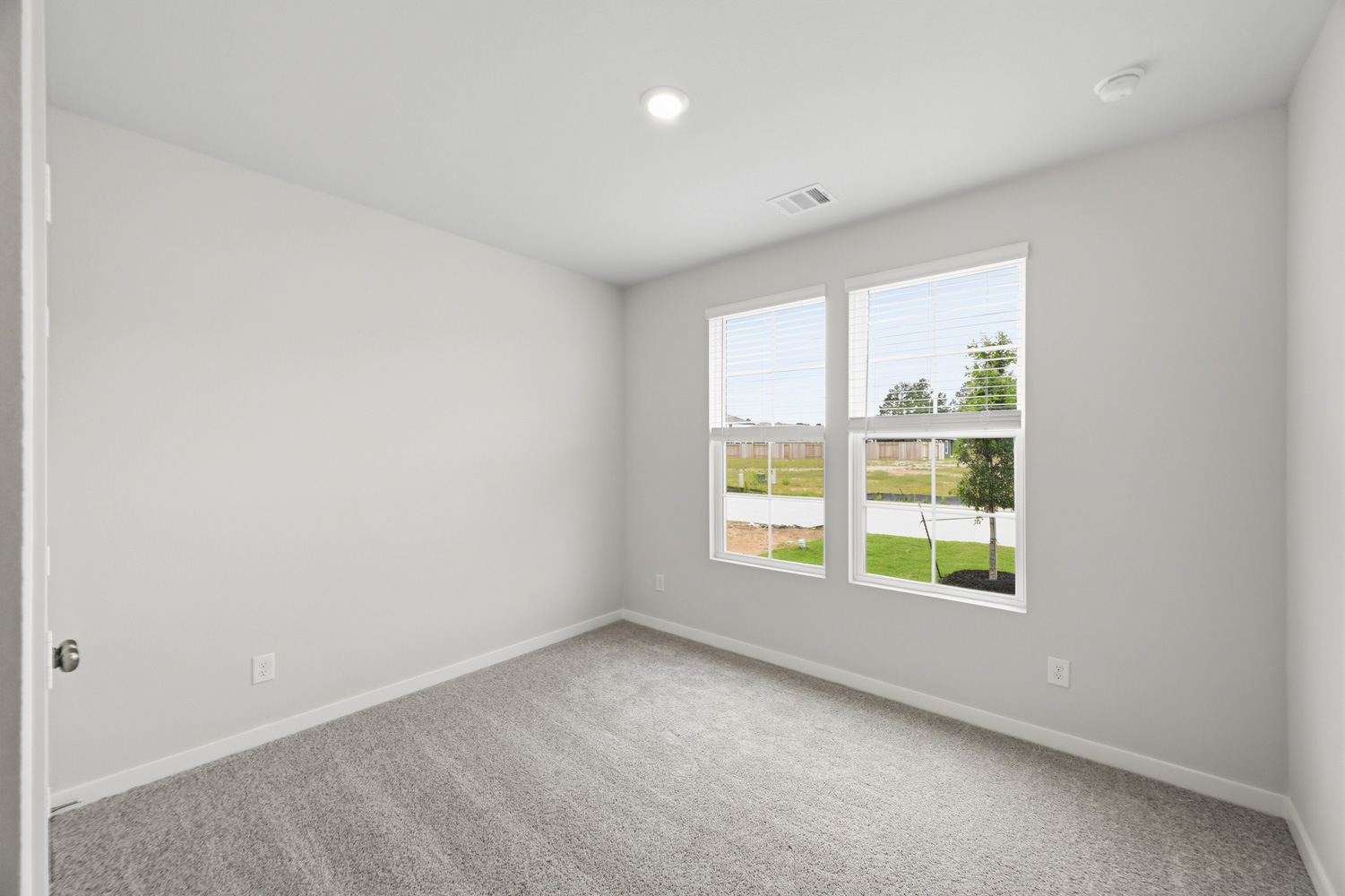 A room with a window and a carpet.