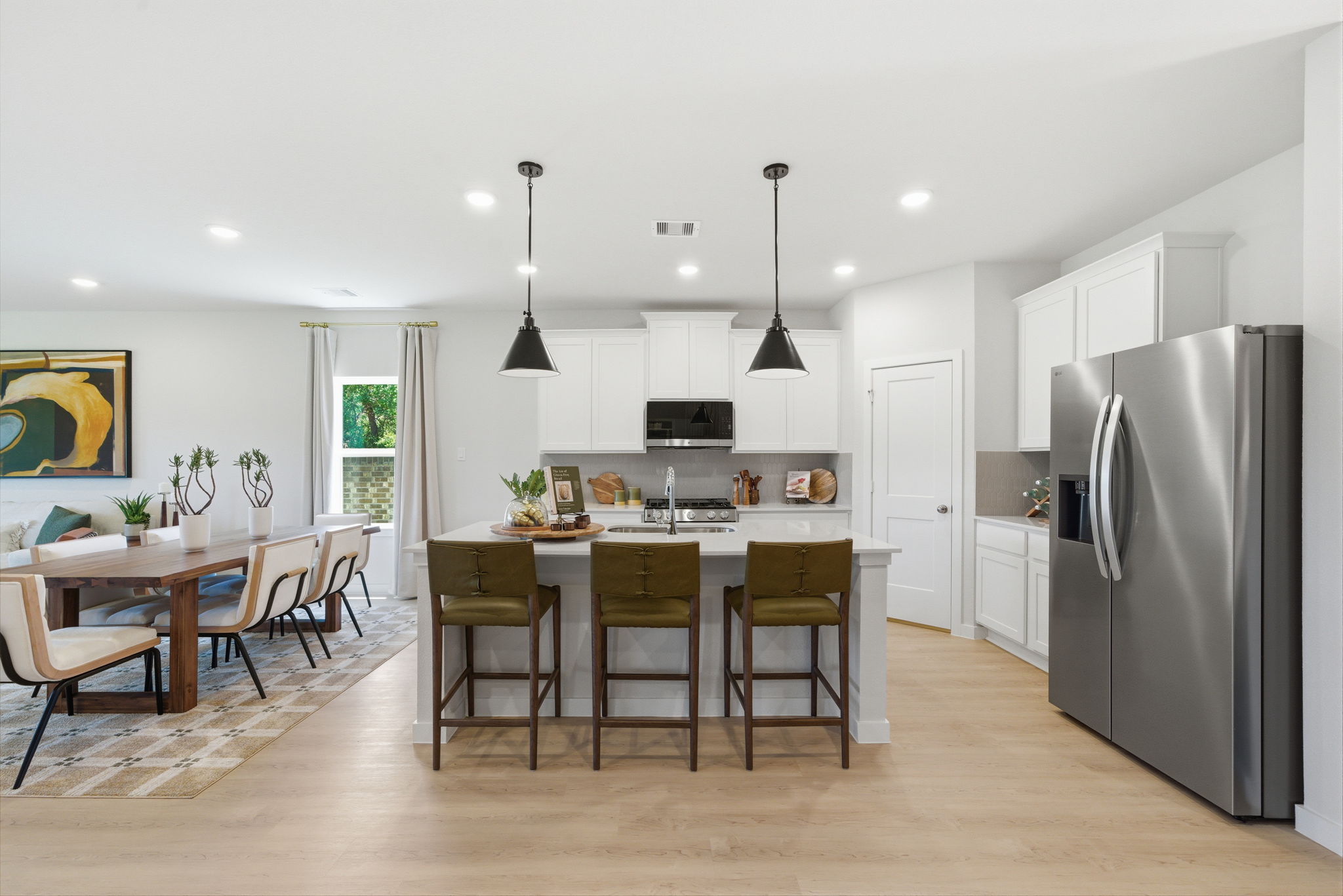 A kitchen with a dining table and a refrigerator.
