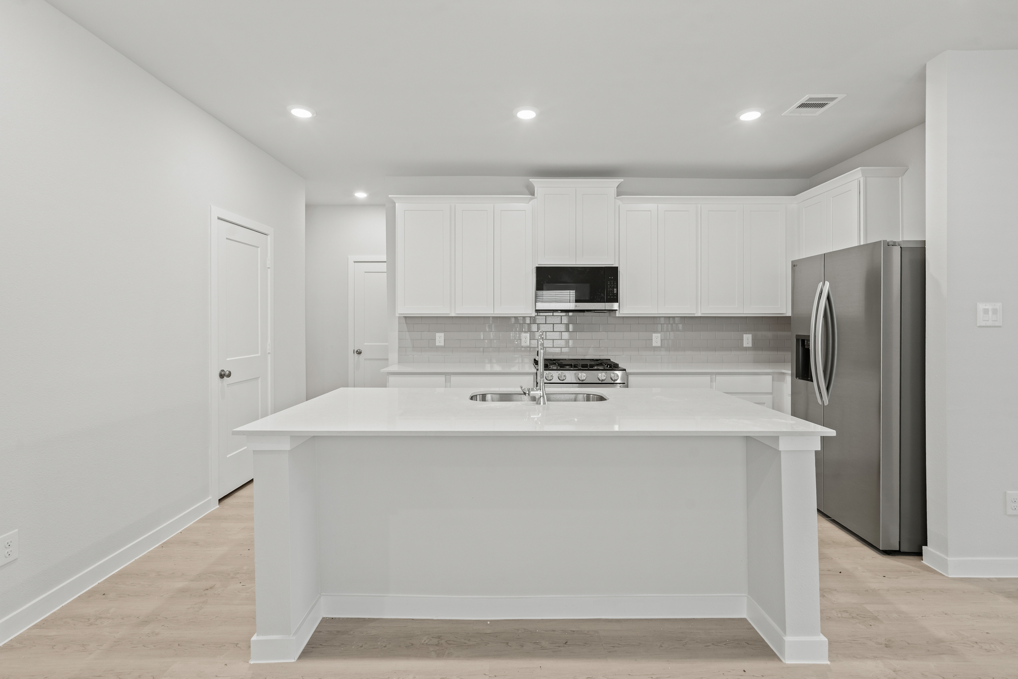 A kitchen with white cabinets.
