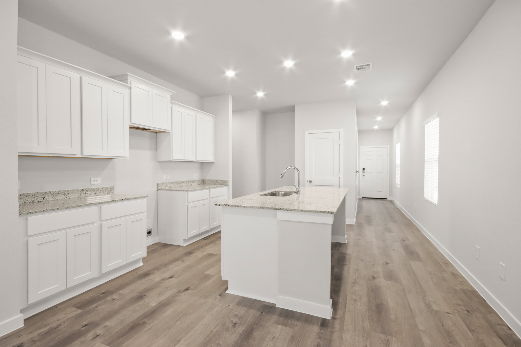 A kitchen with white cabinets.