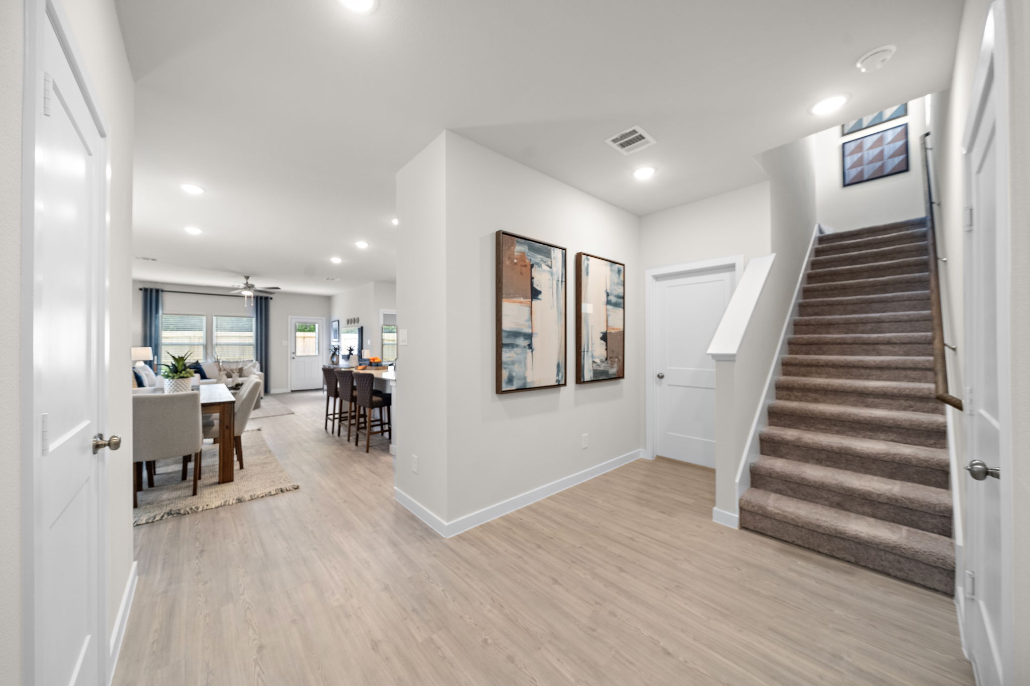 A large room with a wood floor and a wood staircase.